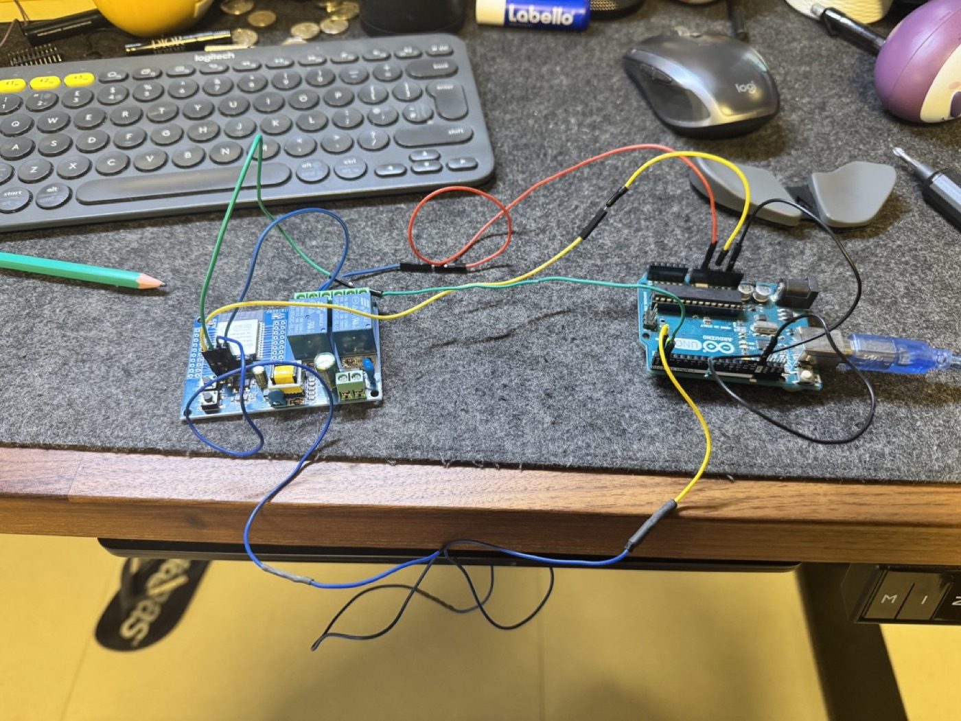Prototype bench: the ESP32 relay board wired to an Arduino UNO with jumper wires on a desk