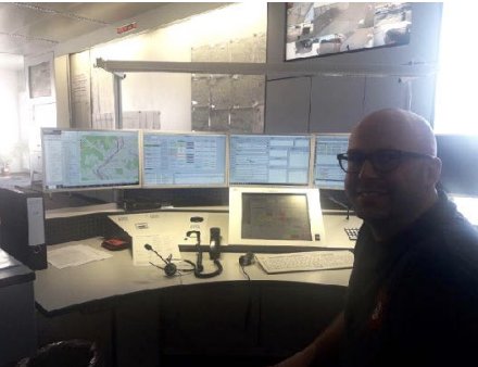 Emergency dispatch control room with a dispatcher at a multi-screen workstation